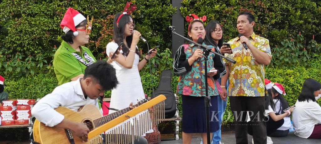 Suasana konser natal di pinggir jalan oleh komunitas muda-mudi dan ibu-ibu dari Gereja Toraja Jemaat Depok, Jumat (22/12/2023).