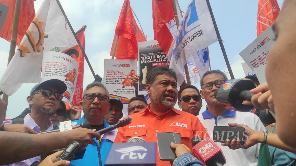 Presiden KSPI Said Iqbal menjawab pertanyaan media di sela-sela unjuk rasa mengecam pemutusan hubungan kerja di sektor tekstil dan logistik, Rabu (3/7/2024), di Jakarta.