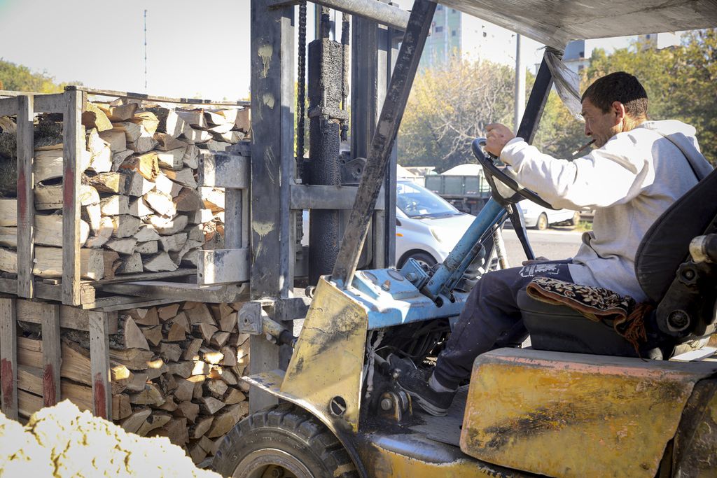 Seorang pekerja tengah menyusun kotak yang berisi kayu bakar yang telah dipotong di pinggir ibu kota Moldova, Chisinau, Sabtu (15/10/2022). Dengan harga gas meningkat hingga enam kali lipat, warga Moldova mulai menggunakan kayu bakar sebagai pengganti gas. 
