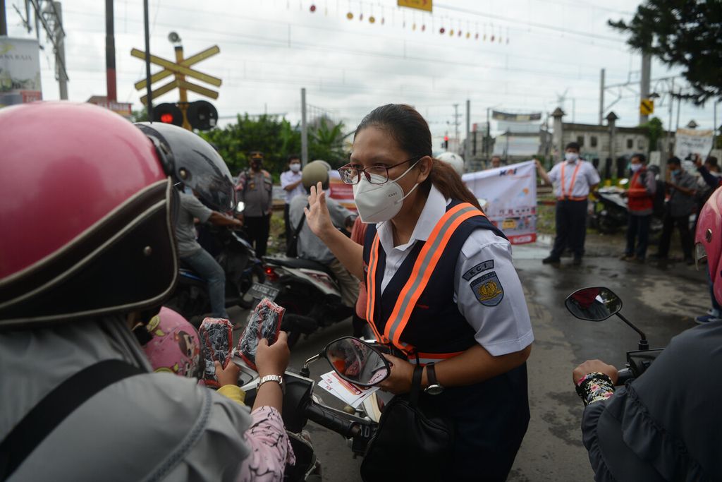 Petugas memberi penjelasan kepada pengguna sepeda motor saat kegiatan sosialisasi keamanan berkendara di pelintasan sebidang sebelah barat Stasiun Klaten, Kabupaten Klaten, Jawa Tengah, Jumat (4/12/2020). 