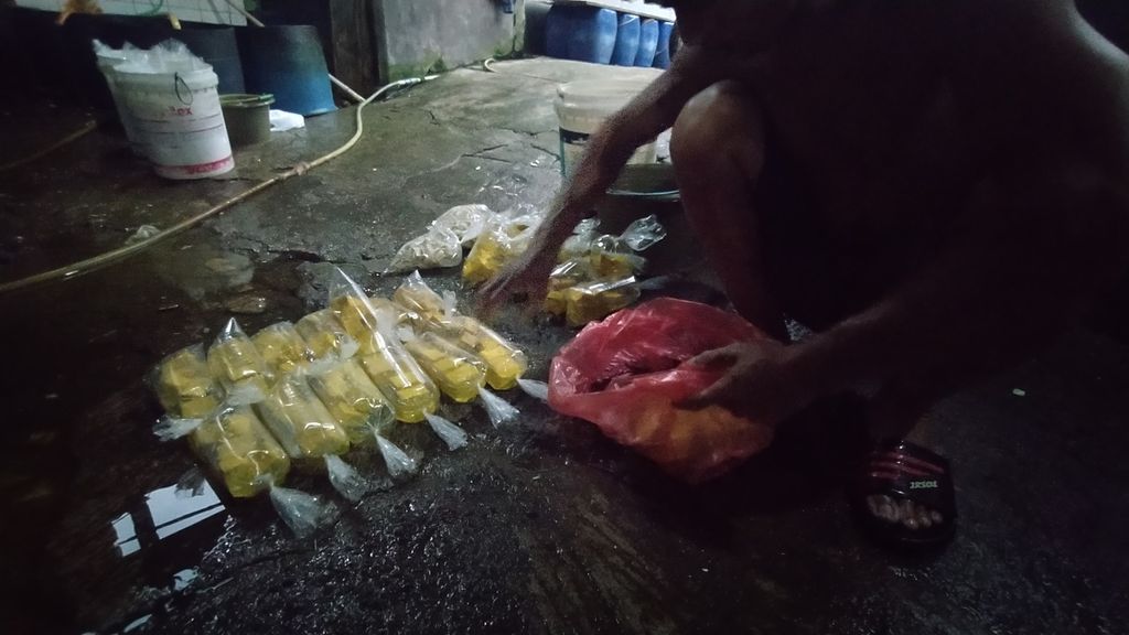 Perajin tahu membungkus tahuyang telah selesai ditiriskan untuk selanjutnya dijual di warung-warung warga, di Kelurahan Pasir Jaya, Kecamatan Bogor Baru, Kota Bogor, Jawa Barat, Sabtu (3/12/2022).
