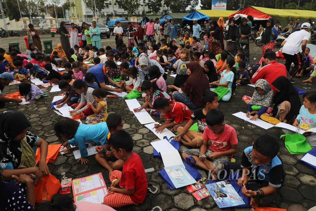 Anak-anak menggambar bersama di Kompleks Kantor Bupati Pasaman Barat, Kabupaten Pasaman Barat, Sumatera Barat, Selasa (1/3/2022). Kegiatan menulis dan menggambar bersama ini sebagai bagian dari <i>trauma healing</i>.