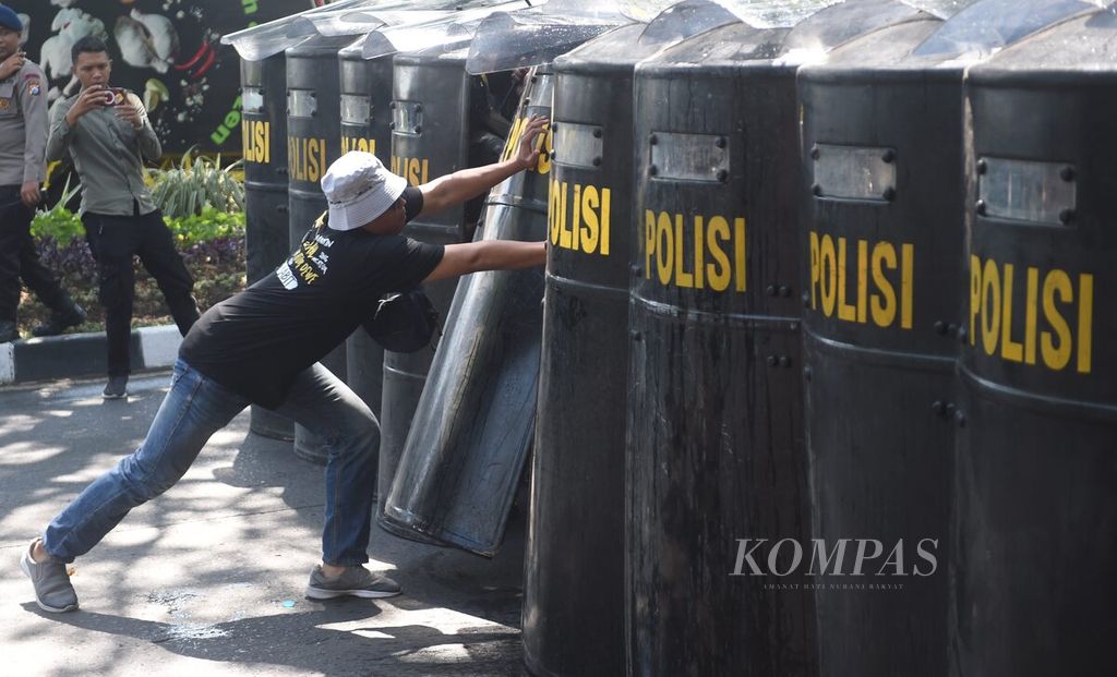 Pengunjuk rasa berusaha menembus penjagaan polisi saat berlangsung geladi bersih pelaksanaan simulasi Sistem Pengamanan Kota (Sispamkota) oleh Polrestabes Surabaya di depan Kantor KPU Kota Surabaya, Jawa Timur, Selasa (13/8/2024). Kegiatan ini dilakukan untuk memperkuat sinergi pihak-pihak terkait dalam mencegah terjadinya hal yang tidak kondusif. Pelaksanaan pilkada serentak 2024 berlangsung pada Rabu, 27 November 2024.