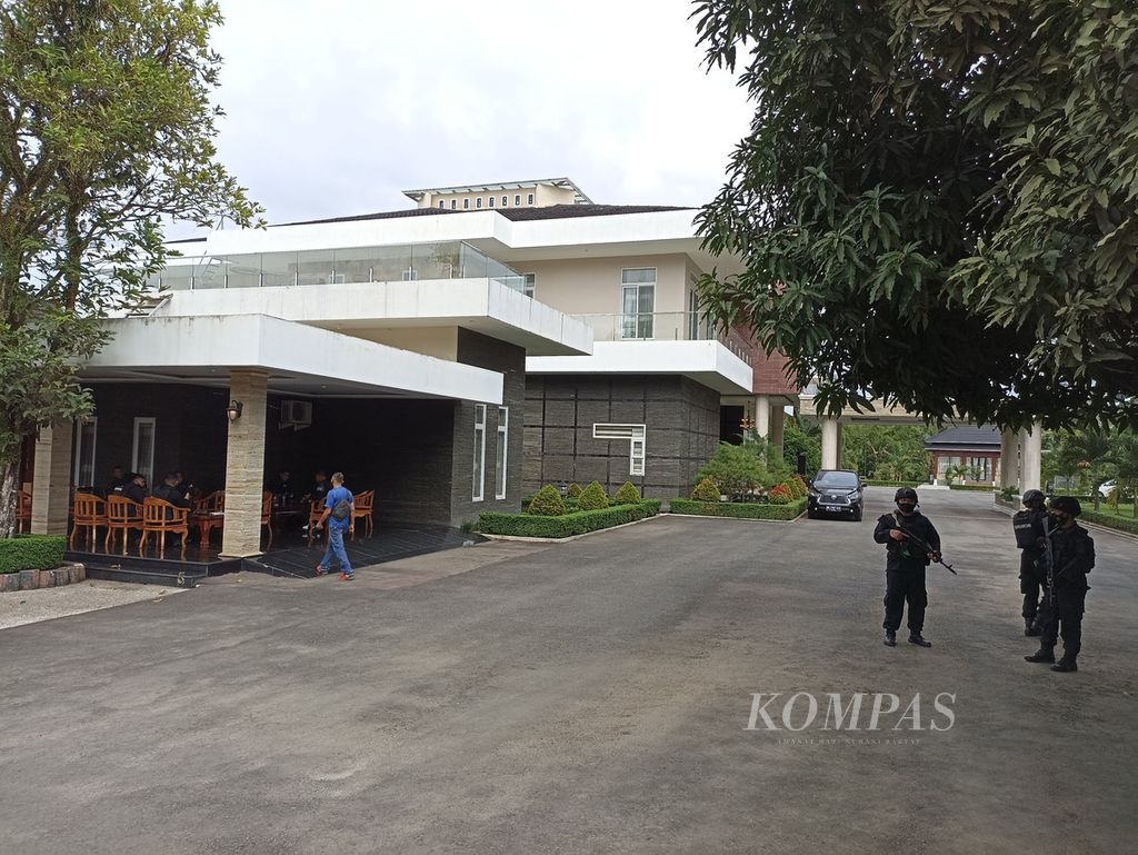 Petugas berjaga mengamankan penggeledahan yang dilakukan penyidik Komisi Pemberantasan Korupsi di rumah pribadi Bupati Langkat Terbit Rencana Perangin-Angin, di Kecamatan Kuala, Langkat, Sumatera Utara, Selasa (25/1/2022).