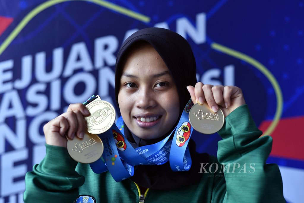 Lifter putri Jawa Timur, Luluk Diana Tri Wijayana, menunjukkan tiga medali emas yang diperolehnya dari kelas 49 kg putri Kejuaraan Nasional Senior Angkat Besi 2022 di Sentul, Bogor, Jawa Barat, Selasa (25/10/2022). 