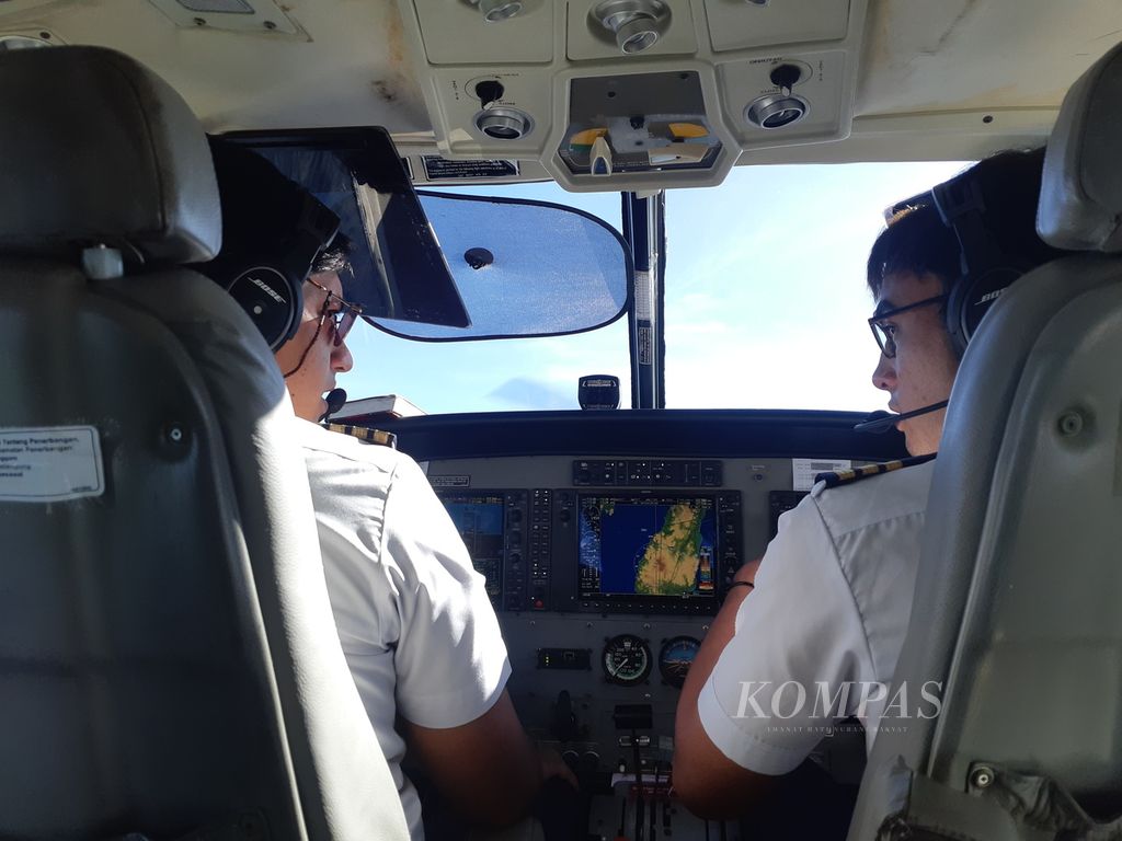 Pilot dan kopilot saat menerbangkan pesawat dari Kota Kupang, Nusa Tenggara Timur, menuju Pulau Kisar, Maluku, Kamis (20/4/2021) pagi. Beberapa orang yang menumpang pesawat itu hendak menyaksikan gerhana matahari total di pulau tersebut.