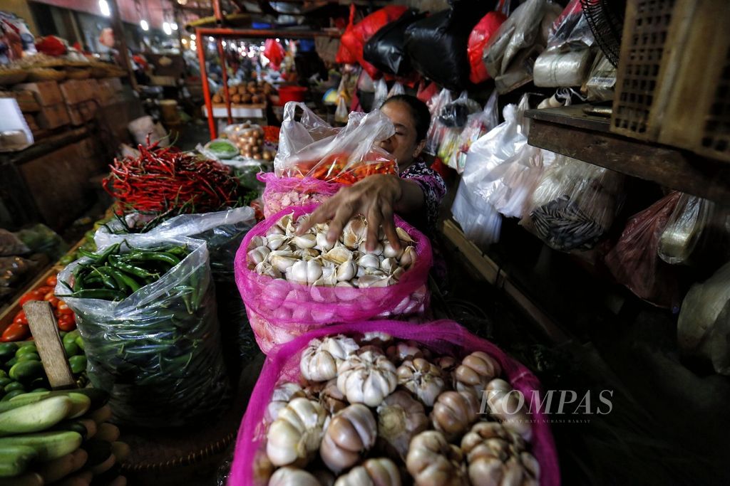 Pedagang bahan pangan melayani pembeli di Pasar Kebayoran Lama, Jakarta Selatan, Senin (3/7/2023). Menurut rilis yang dikeluarkan BPS, bawang putih menjadi salah satu penyumbang inflasi pada Juni 2023. 