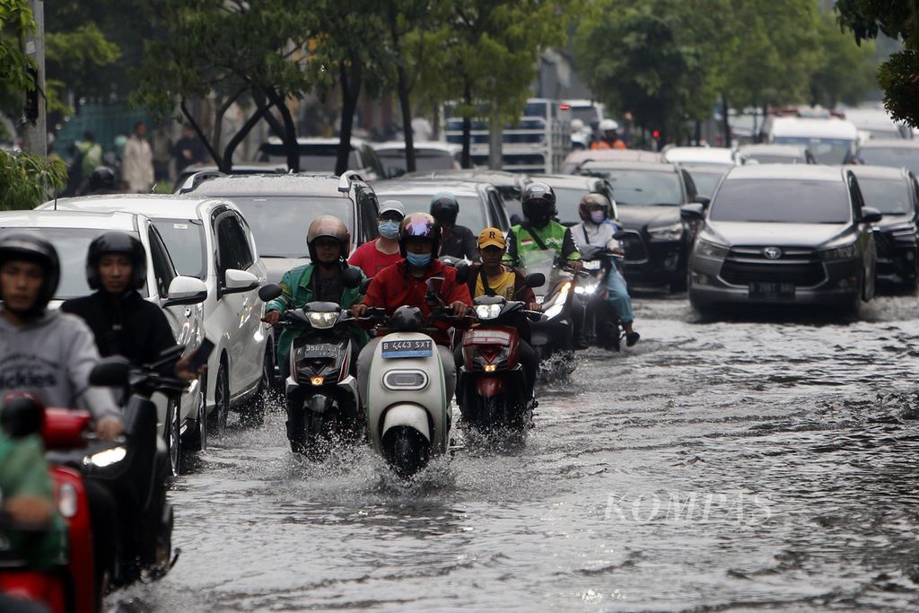 Pengendara berusaha menerobos genangan air di Jalan Tanjung Duren Raya, Jakarta, setelah hujan reda, Jumat (8/12/2023).