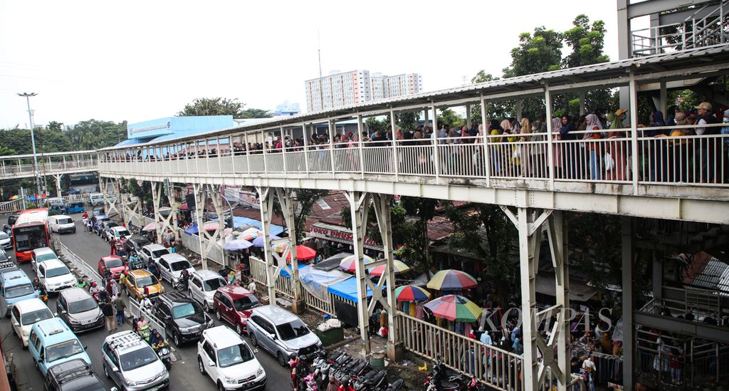 Warga memadati jembatan penghubung antara Stasiun Tanah Abang dan Blok C Pasar Tanah Abang, Jakarta Pusat, Minggu (12/3/2023).