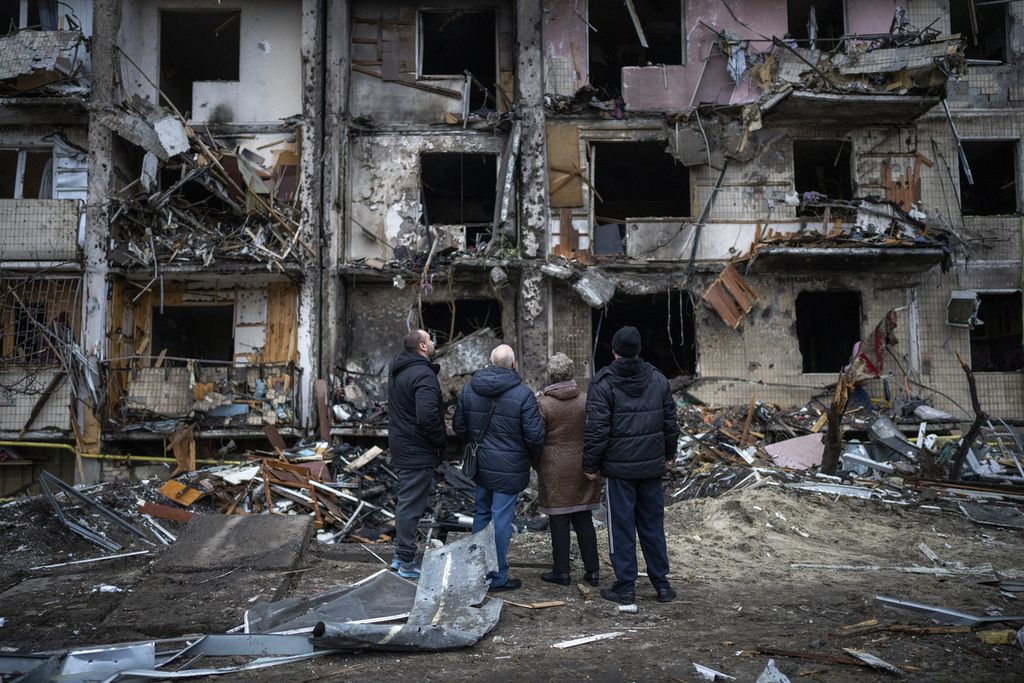 Sejumlah warga Ukraina melihat bangunan tempat tinggal mereka yang rusak akibat serangan roket Rusia di Kiev, Ukraina, Jumat (25/2/2022). 