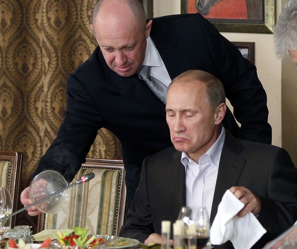 Yevgeny Prigozhin (atas) melayani dengan sajian makanan kepada Vladimir Putin, yang kala itu menjabat Perdana Menteri Rusia, di restoran Prigozhin di luar Moskwa, Rusia, 11 November 2011. 