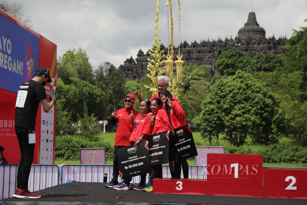 Para pemenang lomba lari Borobudur Marathon 2022 Powered by Bank Jateng kategori Elite Race putri berfoto bersama Gubernur Jawa Tengah Ganjar Pranowo dan Siti Atikoh Supriyanti (istri Ganjar Pranowo) seusai penyerahan penghargaan di Kompleks Candi Borobudur, Magelang, Jawa Tengah, Sabtu (12/11/2022). 