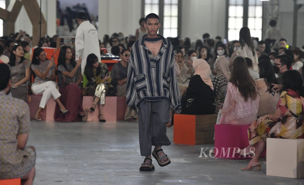 Model membawakan busana rancangan desainer Sapto Djojokartiko dalam pergelaran busana koleksi Sapto Djojokartiko Spring Summer 2023 di Gedung Filateli, Jakarta, Selasa (27/9/2022). 