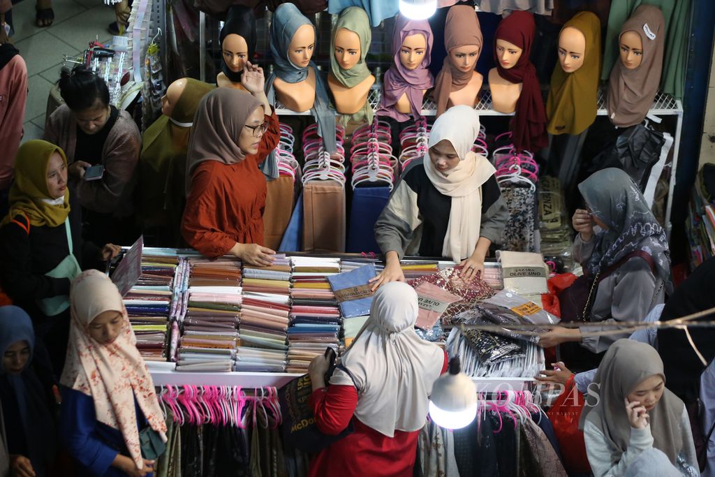 Pengunjung sibuk memilih jilbab. Dua minggu menjelang Lebaran, Pasar Tekstil Tanah Abang, Jakarta Pusat, mulai dipadati warga yang hendak berbelanja pakaian untuk dikenakan saat hari raya, Minggu (24/3/2024). 