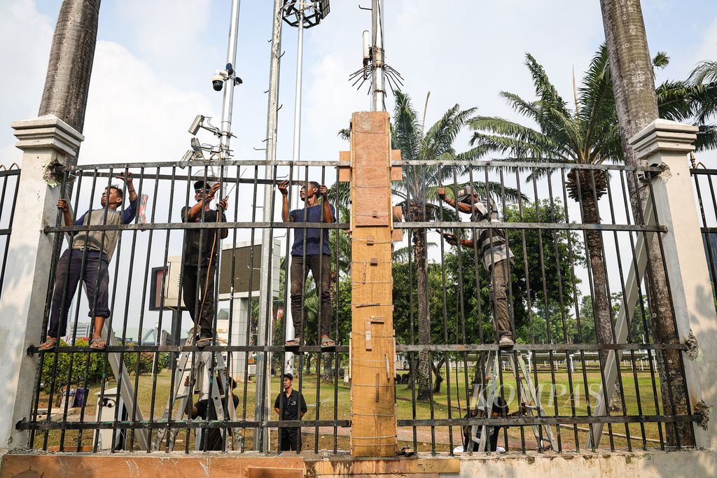 Pekerja memperbaiki pagar yang rusak di Kompleks Parlemen, Jakarta, Jumat (23/8/2024). Berbagai kerusakan terjadi di Kompleks Parlemen dan sekitarnya imbas kerusuhan dalam aksi menolak revisi UU Pilkada yang berlangsung Kamis (22/8/2024). Petugas gabungan bergotong royong memperbaiki fasilitas umum yang rusak.  