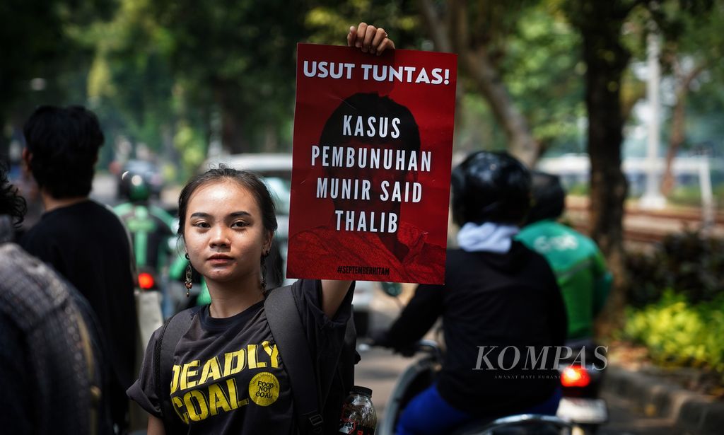 Seorang aktivis Komite Aksi Solidaritas untuk Munir (KASUM) membawa poster tuntutan penuntasan kasus pembunuhan Munir saat menggelar Aksi Peringatan 19 Tahun Meninggalnya Munir di depan Komisi Nasional Hak Asasi Manusia (Komnas HAM), Jakarta, Kamis (7/9/2023). 