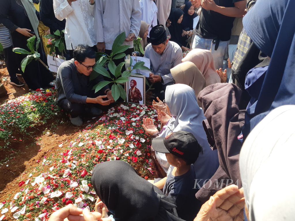 Keluarga berdoa di antara pusara Robiatul Adawiyah (19) di TPU Parung Bingung, Kecamatan Pancoran Mas, Kota Depok, Minggu (12/5/2024). Robiatul merupakan satu dari 11 korban tewas pada kecelakaan bus Trans Putera Fajar di Subang, Jawa Barat.