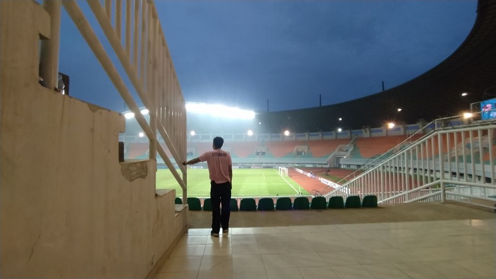 Salah seorang <i>steward </i>tengah berjaga di Stadion Pakansari, Kabupaten Bogor, Jawa Barat, saat pertandingan Malaysia melawan Guam pada laga sepak bola kualifikasi Piala Asia U-17 2023, Rabu (5/10/2022) sore. Laga itu digelar tanpa penonton.