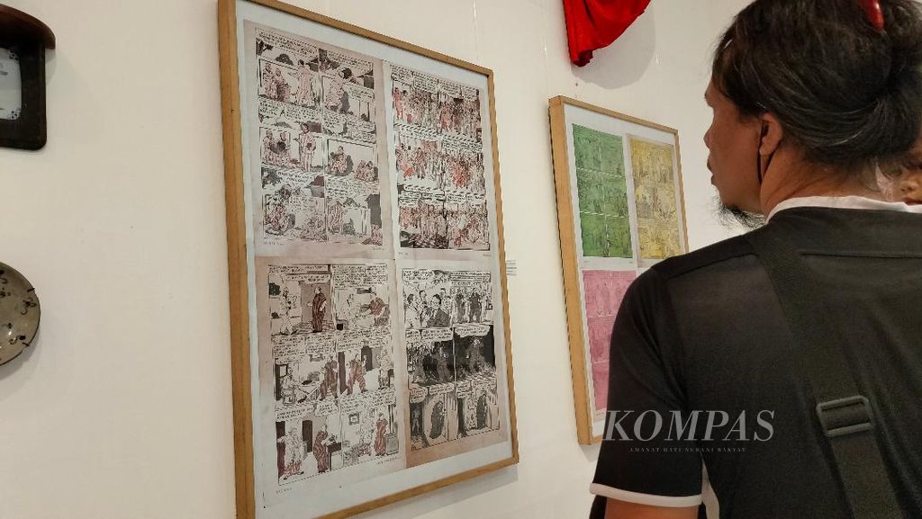 Salah seorang pengunjung melihat salah satu dokumentasi komik yang ditampilkan di pameran Sintjhia di Bentara Budaya Yogyakarta, Senin (16/1/2023).