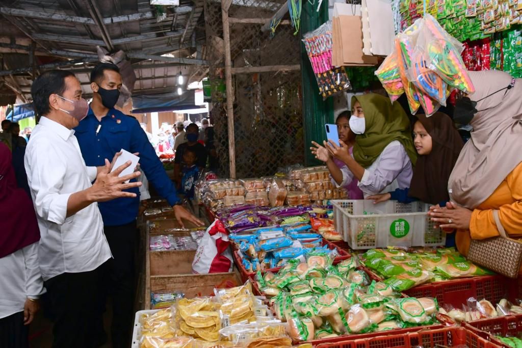 Presiden Joko Widodo berinteraksi dengan pedagang sembari menyerahkan bantuan sosial di Pasar Sukamandi, Kabupaten Subang, Selasa (12/7/2022).