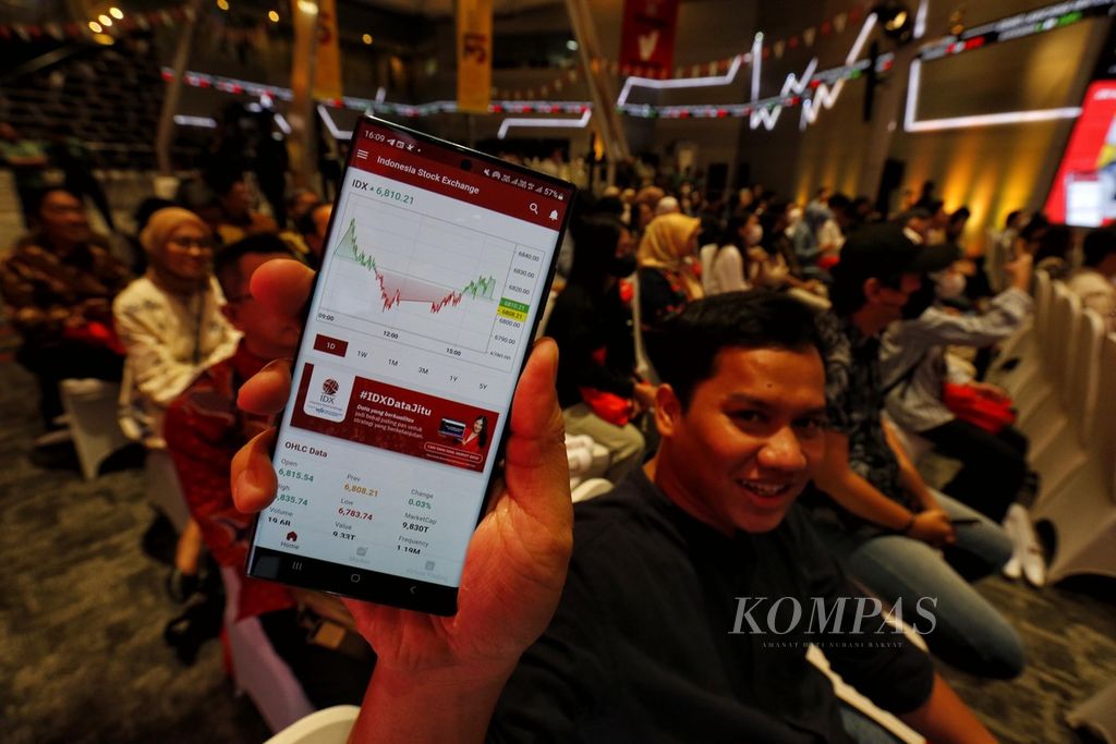 Tamu undangan menunjukkan aplikasi IDX Mobile saat diluncurkan di Gedung Bursa Efek Indonesia, Jakarta, Kamis (13/7/2023).