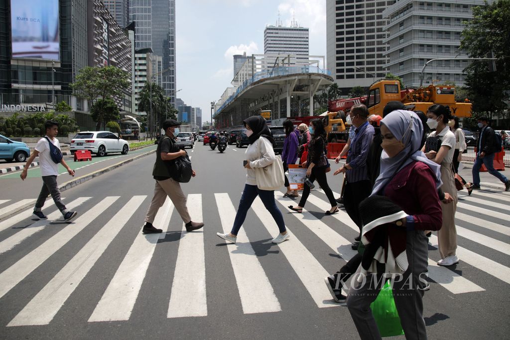 Warga menyeberangi <i>pelican cross </i>di sekitar proyek revitalisasi halte bus Transjakarta Tosari di Jalan MH Thamrin, Jakarta, Selasa (6/9/2022). Pengerjaan ini merupakan bagian dari proyek revitalisasi 46 halte Transjakarta yang dimulai sejak April 2022. 