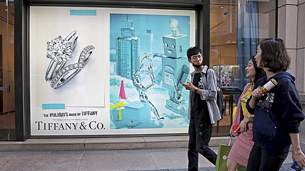 Turis China berjalan di depan butik Tiffany & Co di Canton Road, kawasan pusat perbelanjaan barang-barang mewah di Hong Kong, 29 November 2018. Laju pertumbuhan ekonomi China yang tertahan memengaruhi daya beli konsumen China terhadap barang-barang mewah.