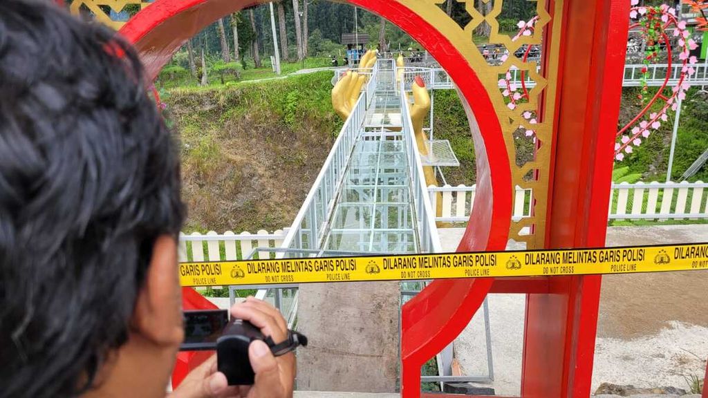 Garis polisi dipasang di jembatan kaca pada wisata ”The Geong” di Kecamatan Sumbang, Kabupaten Banyumas, Jawa Tengah, Rabu (25/10/2023). Seorang wisatawan tewas setelah jembatan kaca itu pecah.