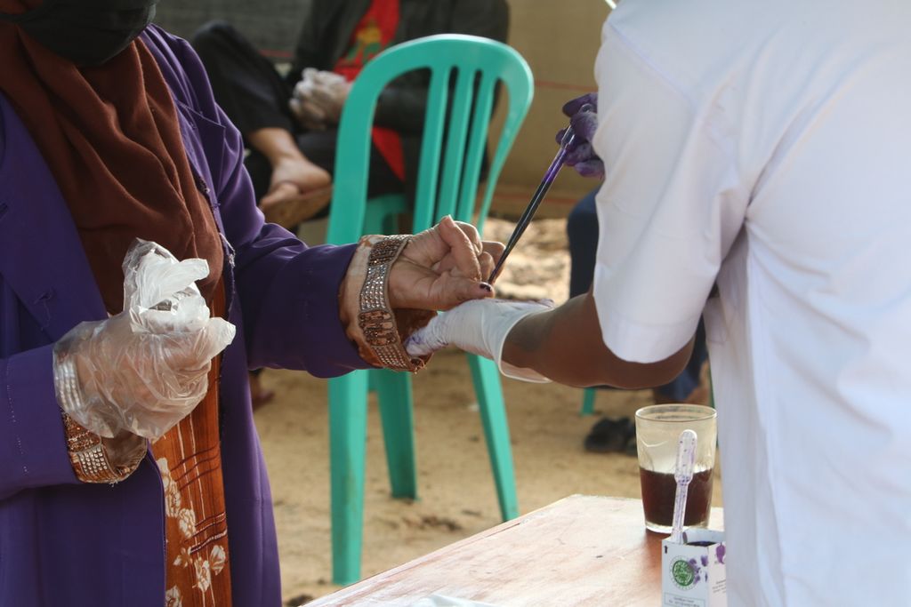 Petugas meneteskan tinta kepada warga yang telah menggunakan hak pilih dalam Pemilihan Kepala Daerah Kabupaten Bandung di TPS 003 Desa Lamajang, Kecamatan Pangalengan, Kabupaten Bandung, Jabar, Rabu (9/12/2020).