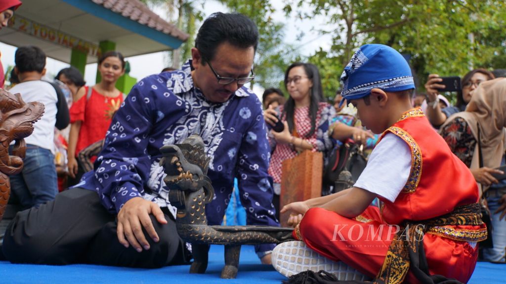 Deputy Mayor of Yogyakarta Heroe Poerwadi (left) playing dakon with participants of the Traditional Children's Dolanan Festival, in Yogyakarta City, Saturday (11/24/2018).