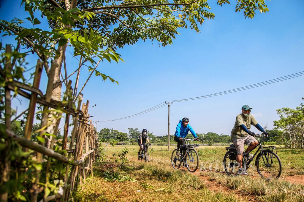 Pesepeda melintasi padang rumput di kawasan Cibogo, Cisauk, Kabupaten Tangerang, Banten, Sabtu (18/7/2020). Bersepeda dapat menjadi pilihan olahraga masyarakat di tengah puasa Ramadhan.