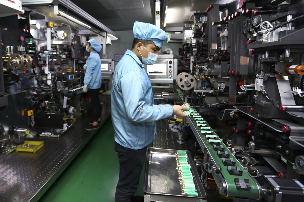 Sejumlah pekerja menaruh baterai-baterai pada mesin di pabrik pembuatan baterai litium di Huaibei, Provinsi Anhui, 14 November 2020. Perusahaan-perusahaan China mendominasi pasar baterai untuk kendaraan listrik dunia. 