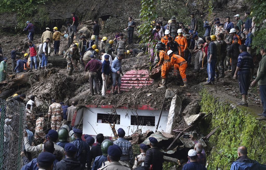 Petugas penyelamat memindahkan puing-puing dan lumpur saat mencari korban yang diperkirakan terjebak setelah terjadi tanah longsor di dekat sebuah kuil di luar kota Shimla, Himachal Pradesh, India, 14 Agustus 2023. 