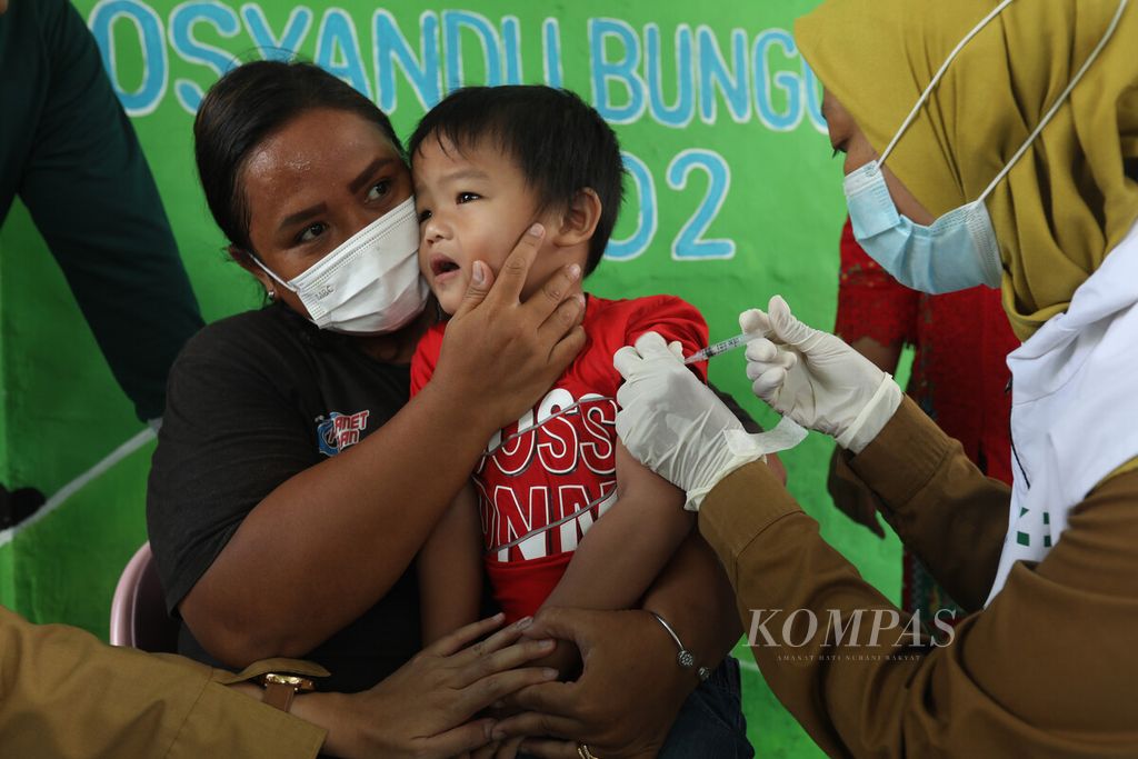 Dokter Puskesmas Kecamatan Kramat Jati menyuntikkan imunisasi kepada seorang anak di Posyandu Bungur, Kramat Jati, Jakarta Timur, Selasa (22/11/2022).  