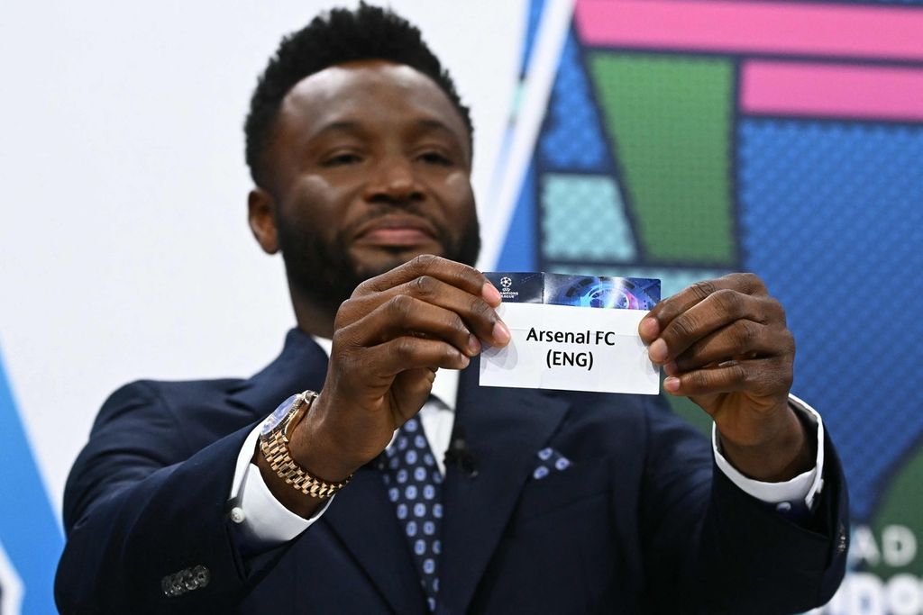 Mantan pesepak bola asal Nigeria sekaligus duta UEFA, John Obi Mikel, mengangkat kertas bertuliskan Arsenal saat undian pertandingan babak perempat final Liga Champions di markas UEFA di Nyon, Swiss, Jumat (15/3/2024). 