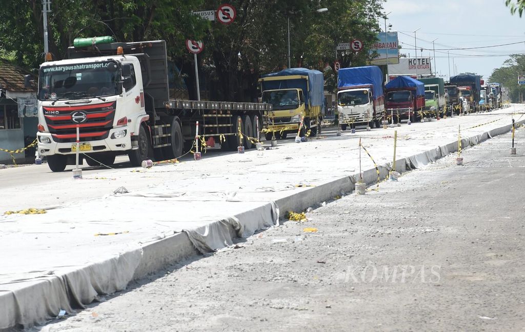 Antrean kendaraan di proyek perbaikan Jalan Bypass di Kota Mojokerto, Jawa Timur, Selasa (4/4/2023). Jalan tersebut merupakan jalan nasional yang menghubungkan Surabaya-Mojokerto. Untuk menghindari penumpukan kendaraan selain pengalihan jalur melalui dalam Kota Mojokerto, dilakukan rekayasa lalu lintas sistem buka tutup melewati jalan yang belum dicor atau bagian jalan yang selesai dicor. Jalur tersebut menjadi jalur penting pada musim mudik Lebaran.