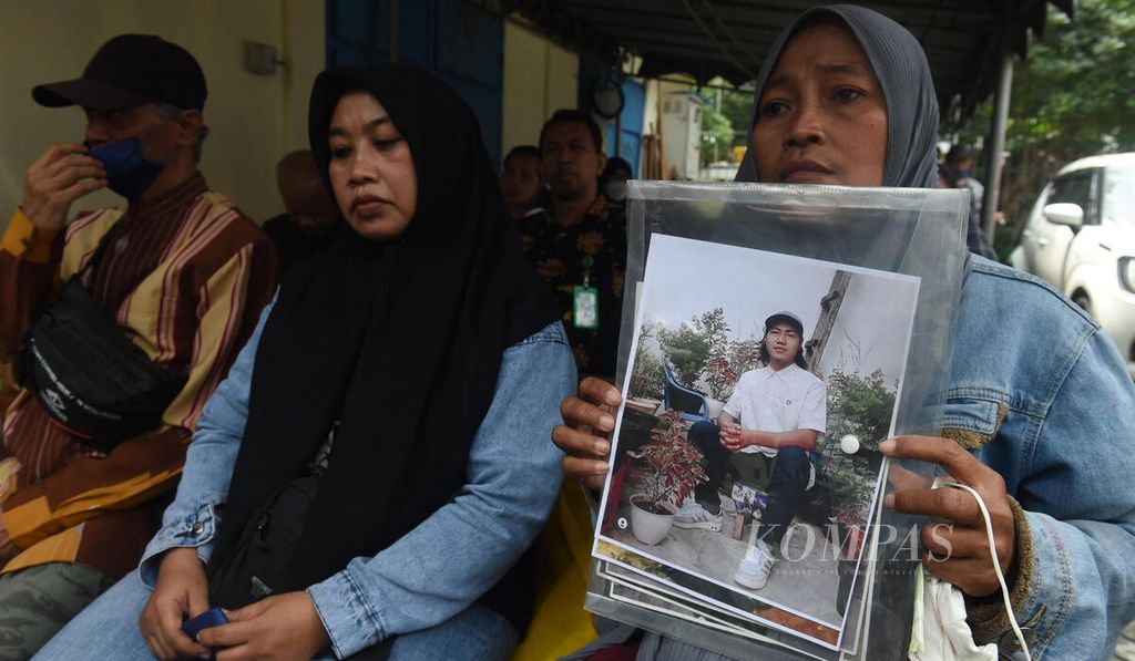 Rini Hanifah (43) memegang foto anaknya Agus Rainsyah yang menjadi korban dalam Tragedi Kanjuruhan dalam sidang perdana kasus Tragedi Kanjuruhan di Pengadilan Negeri Surabaya, Jawa Timur, Senin (16/1/2023).