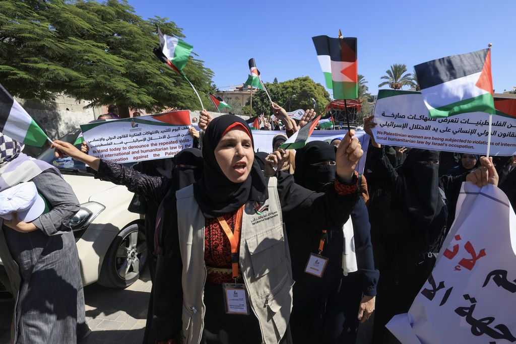 Perempuan warga Palestina mengangkat plakat dan spanduk saat demonstrasi anti-Israel di depan gedung UNESCO di Kota Gaza, Minggu (10/9/2023). 
