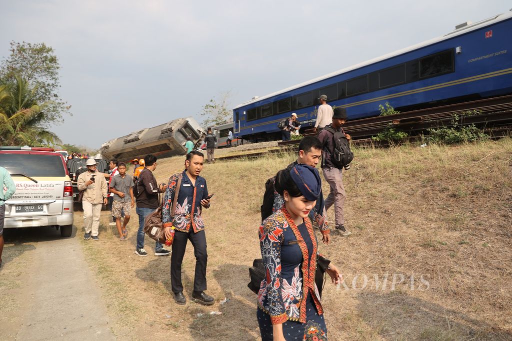 Pramugari dan penumpang berjalan kaki setelah KA Argo Semeru anjlok di Dusun Kalimenur, Desa Sukoreno, Sentolo, Kulon Progo, Selasa (17/10/2023).