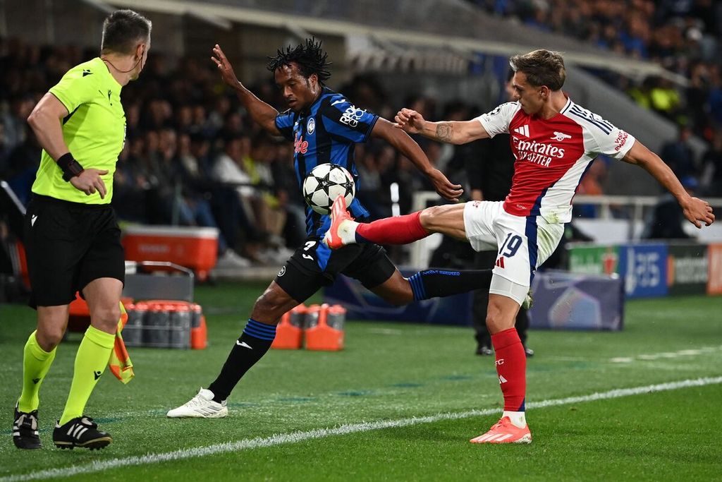 Pemain Arsenal, Leandro Trossard, (kanan) berebut bola dengan pemain Atalanta, Juan Cuadrado (tengah), pada laga Liga Champions Eropa di Stadion Gewiss, Bergamo, Italia, Jumat (20/9/2024) dini hari WIB. Laga berakhir imbang 0-0.