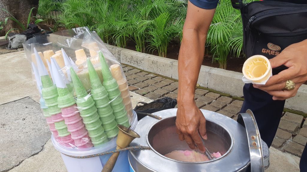 Penjual es krim keroncong, Ali (46), mengambilkan es krim untuk pembeli, Kamis (8/10/2020), di Jalan Merdeka Barat, Jakarta.