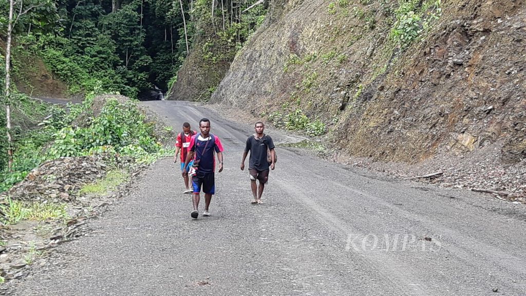 Warga yang berjalalan kaki melewati Jalan Trans-Papua di Distrik Benawa, Kabupaten Yalimo, pada 8 September 2018.