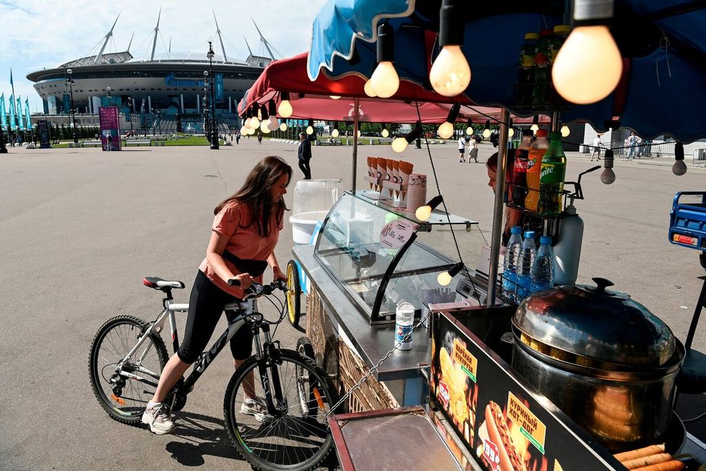 Seorang perempuan belia membeli es krim di depan Stadion Saint Petersburg, Rusia (9/6/2021) sebelum munculnya varian virus Omicron. 