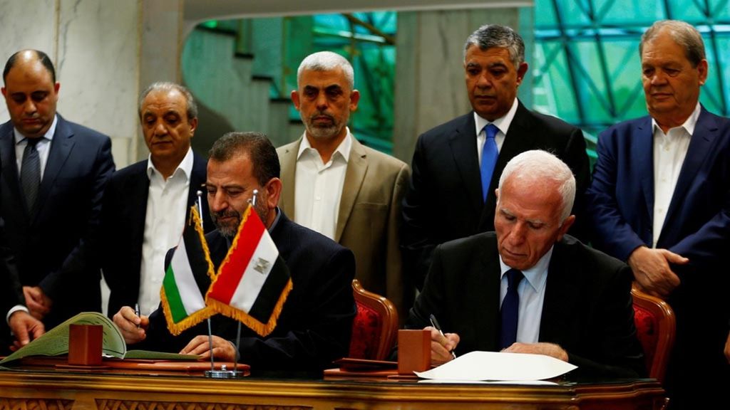 Kepala delegasi Hamas Saleh Arouri (duduk, kiri) dan pemimpin Fatah Azzam Ahmad (duduk, kanan) menandatangani kesepakatan rekonsiliasi di Kairo, Mesir, 12 Oktober 2017. 