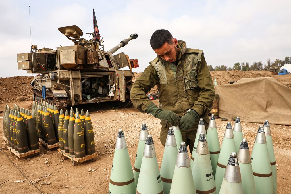 Seorang tentara dari unit artileri Israel sedang menyiapkan amunisi untuk menyerang Hamas di Gaza di dekat perbatasan dengan Jalur Gaza pada Selasa (5/12/2023). 
