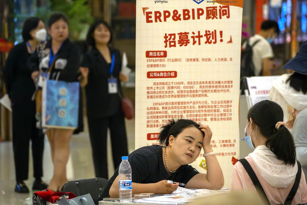 Seorang perekrut berbicara dengan pelamar di stan bursa kerja di sebuah pusat perbelanjaan di Beijing, China, Jumat (9/6/2023).