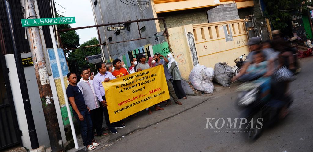 Suasana warga Jalan Tanah Tinggi I Gang 5, Johar Baru, Senen, Jakarta Pusat, membawa spanduk penolakan penggantian nama jalan di wilayah permukiman mereka, Rabu (29/6/2022).