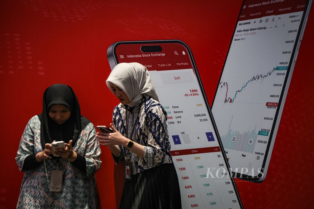 Panitia berdiri di depan gambar aplikasi Bursa Efek Indonesia (BEI) saat seremoni penutupan perdagangan BEI tahun 2023 di Gedung BEI, Jakarta, Jumat (29/12/2023). 