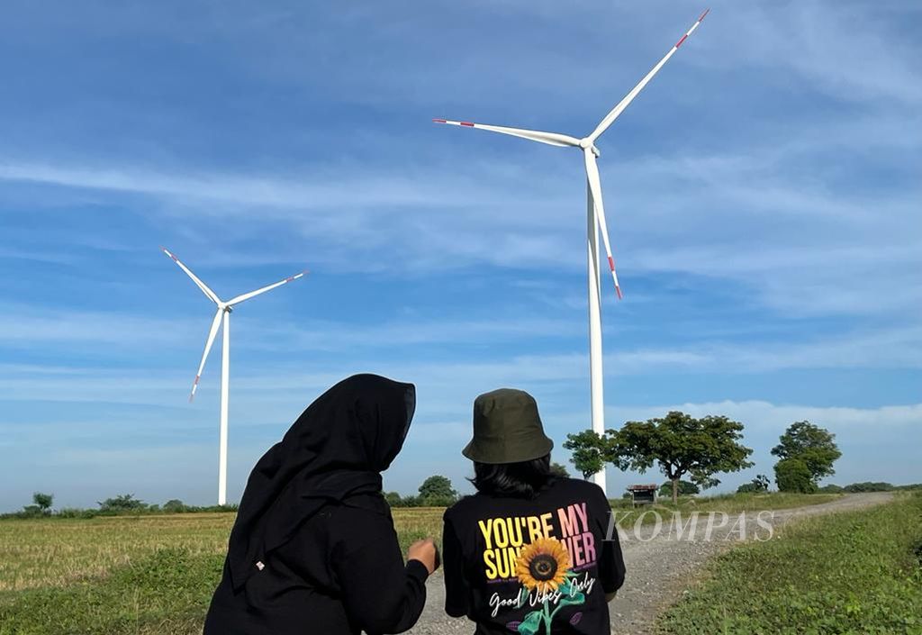 Pengunjung menikmati pemandangan kincir angin di PLTB Tolo, Jeneponto, Sulawesi Selatan, Sabtu (23/4/2022). Sejak beroperasi, kawasan pembangkit listrik ini jadi tujuan wisata bagi warga.