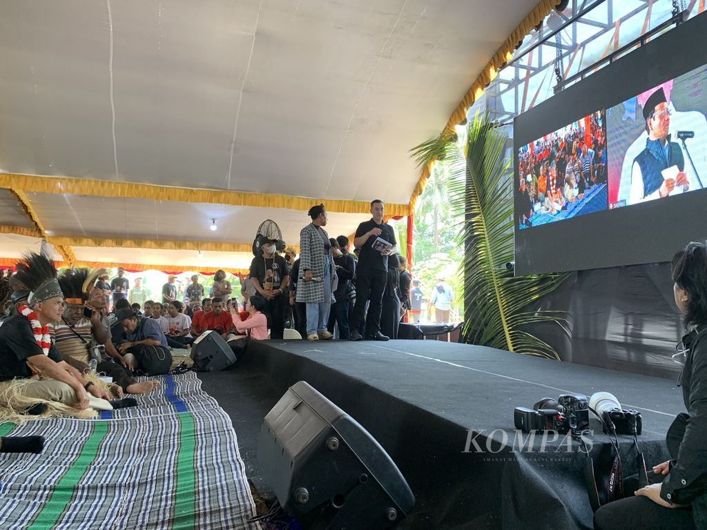 Calon presiden Ganjar Pranowo menyimak pidato calon wakil presidennya, Mahfud MD, dari Kampung Waninggap Nanggo, Distrik Semangga, Merauke, Papua Selatan, Selasa (28/11/2023). Mahfud tengah berada di Sabang, Aceh.